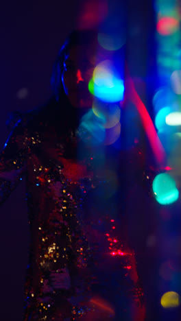 Vertical-Video-Of-Woman-In-Nightclub-Bar-Or-Disco-Dancing-With-Sparkling-Lights-In-Background-2